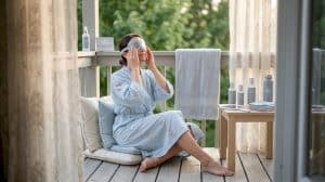 Woman applying cool gel mask at vanity