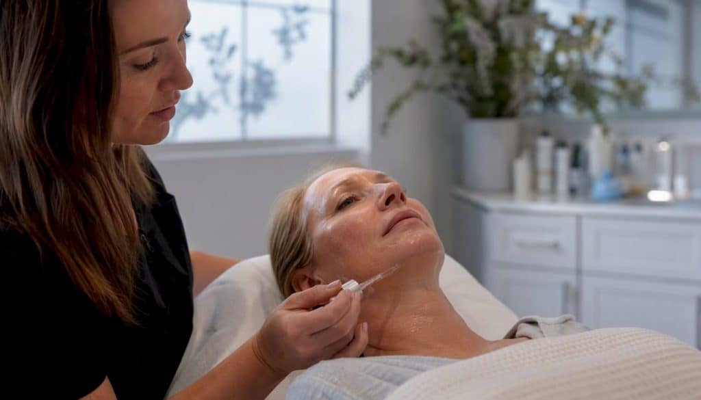Esthetician applying facial serum treatment