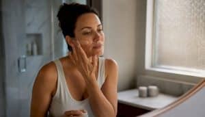 Woman applying tinted sunscreen to face
