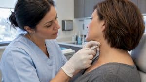 Clinician carefully removing a small skin tag