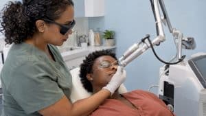 Practitioner positions CO2 laser near patient's cheek